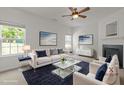 Cozy living room featuring a fireplace, ceiling fan, and comfortable seating arrangement at 4805 Ayden Mill Rd, Apex, NC 27539