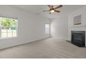 Neutral living area featuring a cozy fireplace, soft carpet, and bright windows at 4805 Ayden Mill Rd, Apex, NC 27539