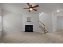 Bright living room with plush carpet, fireplace, and staircase to the second floor at 4805 Ayden Mill Rd, Apex, NC 27539