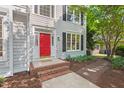 Inviting entryway showcasing a vibrant red door, brick steps, and lush landscaping at 4900 American Dr, Durham, NC 27705