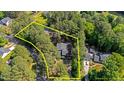 A serene home nestled within a property line surrounded by lush greenery and tall trees from an aerial perspective at 512 Stratford Dr, Zebulon, NC 27597