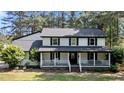 Charming two-story home showcasing a classic design with a cozy front porch and lush landscaping at 512 Stratford Dr, Zebulon, NC 27597