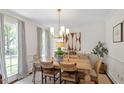 Bright dining room featuring a wood table, modern lighting, and stylish decor at 5709 Lakehaven Dr, Raleigh, NC 27612