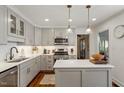 Modern kitchen with stainless steel appliances, gray cabinetry, and quartz countertops at 5709 Lakehaven Dr, Raleigh, NC 27612