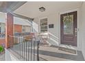 Welcoming covered porch with seating area, dark railing, and updated paint at 623 Massey Ave, Durham, NC 27701