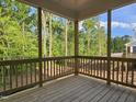 A wood frame back porch with wood rails and view of trees at 629 Conover Rd, Durham, NC 27703
