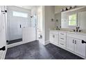 Modern bathroom featuring a double vanity with black hardware, a tiled shower with a glass enclosure at 629 Conover Rd, Durham, NC 27703
