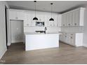 Modern kitchen featuring white cabinets, subway tile backsplash, and a kitchen island with pendant lighting at 629 Conover Rd, Durham, NC 27703