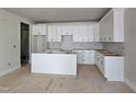 Bright kitchen featuring white cabinets, a center island, and ample storage space at 629 Conover Rd, Durham, NC 27703