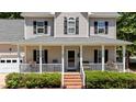 Inviting front porch featuring a classic design, decorative wreath, and comfortable seating arrangements at 6509 Virgilia Ct, Raleigh, NC 27616