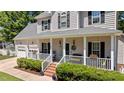Inviting front porch with white railing, manicured landscaping, and cozy seating area at 6509 Virgilia Ct, Raleigh, NC 27616