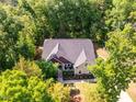 An aerial view shows the well-maintained property surrounded by lush green trees at 67 Crimson Way, Pittsboro, NC 27312