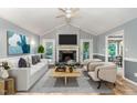 Bright living room features a ceiling fan, fireplace, and two comfortable chairs at 6820 Chamonix Pl, Raleigh, NC 27613