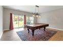 Bright dining room features a classic pool table, area rug, and sliding glass doors to the outdoor space at 710 Samuel Cary Dr, Cary, NC 27511