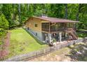 Exterior angled view of a two-story home with a screened-in porch and lush backyard at 7723 Johnson Mill Rd, Bahama, NC 27503