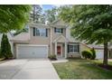 Inviting two-story home with a well-kept lawn, a two-car garage, and a striking red front door at 809 Amarillo Rose Ln, Durham, NC 27712