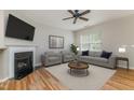 Inviting living room with a fireplace, plush seating, and a ceiling fan at 809 Amarillo Rose Ln, Durham, NC 27712