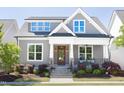 Inviting home exterior with a cozy front porch, decorative columns, and manicured garden at 92 Cardinal Ridge Rd, Chapel Hill, NC 27516