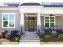 Welcoming front porch with stone columns, elegant lighting, and cozy seating area at 92 Cardinal Ridge Rd, Chapel Hill, NC 27516