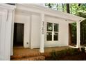 Welcoming exterior with brick steps, covered entrance, white siding, black house numbers, and manicured landscaping at Lot 3260 Yorkshire Cir, Sanford, NC 27332