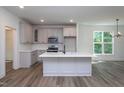 An open kitchen layout with gray cabinets, a center island, and views to the exterior at Lot 3260 Yorkshire Cir, Sanford, NC 27332