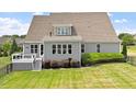 A well kept lawn with a deck and multiple windows in the rear of the house at 10 Princeton Manor Dr, Youngsville, NC 27596