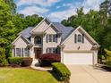 Charming two-story home featuring a manicured lawn, blue shutters, and a two-car garage at 100 Panoramic Ct, Cary, NC 27519