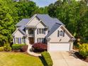 Charming two-story home featuring a manicured lawn, blue shutters, and a two-car garage at 100 Panoramic Ct, Cary, NC 27519