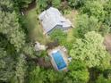 This home has a swimming pool and a well-maintained lawn in a serene, wooded setting at 1000 Phils Creek Rd, Chapel Hill, NC 27516