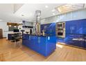 Modern kitchen with custom blue cabinets, stainless steel appliances, and a large island at 1000 Phils Creek Rd, Chapel Hill, NC 27516