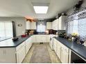 Well-lit kitchen featuring white cabinets, blue countertops, neutral walls and stainless steel appliances at 107 N Pearl St, Princeton, NC 27569
