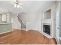 Open-concept living room with hardwood floors, fireplace, and staircase at 111 Grey Elm Trl, Durham, NC 27713