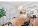 Bright dining room with a modern chandelier and access to the outdoor patio at 112 Homegate Cir, Apex, NC 27502