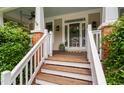 Inviting front porch with stained wood floors, white railings, and access to the front door at 112 Homegate Cir, Apex, NC 27502