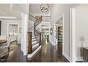 Inviting foyer featuring a curved staircase, wood floors, and open access to other rooms at 113 Amberwing Ct, Holly Springs, NC 27540