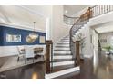 Elegant foyer with dark wood floors, curved staircase and dining room at 113 Amberwing Ct, Holly Springs, NC 27540