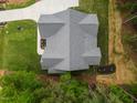 Aerial view of a well-manicured home with a gray roof, lawn, and an elongated driveway surrounded by trees at 1218 Red Cedar Ct, Youngsville, NC 27596