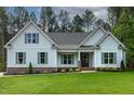 A well-manicured lawn complements this charming home with blue siding, shutters, and brick accents on the facade at 1218 Red Cedar Ct, Youngsville, NC 27596