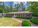 Beautiful home exterior featuring a well-maintained lawn, brick walkway, and mature shrubbery at 1305 Kimberly Dr, Raleigh, NC 27609
