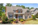 Charming two-story home with a welcoming front porch and nicely landscaped front yard, perfect for curb appeal at 1437 Chelton Oaks Pl, Raleigh, NC 27614