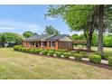 Well-maintained brick home with manicured landscaping and covered parking at 1647 Turner Rd, Mebane, NC 27302