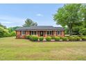 Charming brick home with a covered front porch and mature landscaping at 1647 Turner Rd, Mebane, NC 27302