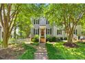 Charming two-story home featuring gray siding, black shutters, a red front door, and a lush front yard at 1806 Carrington Dr, Raleigh, NC 27615