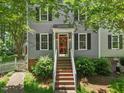 Close up of the red front door, gray siding, black shutters, and steps leading to the entrance at 1806 Carrington Dr, Raleigh, NC 27615