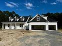 Charming new construction featuring a three-car garage and dormer windows under a blue sky at 196 Cozy Brook Ct, Clayton, NC 27520