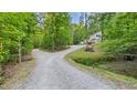 Driveway leading to the house with lush greenery and mature trees surrounding the home at 196 Tara Ln, Timberlake, NC 27583