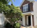 Charming brick-accented home with a black front door and lush greenery framing the entrance at 2018 Groundwater Pl, Raleigh, NC 27610