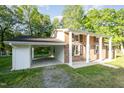 Brick home featuring an attached carport, front porch with stately columns and manicured lawn at 2027 Jefferson Dr, Hillsborough, NC 27278