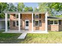 A brick home featuring a covered front porch with white columns and black shutters at 2027 Jefferson Dr, Hillsborough, NC 27278