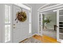 Welcoming foyer with a hardwood floor, decorative wreath, and an open view to a cozy home office at 204 Rossburn Way, Chapel Hill, NC 27516